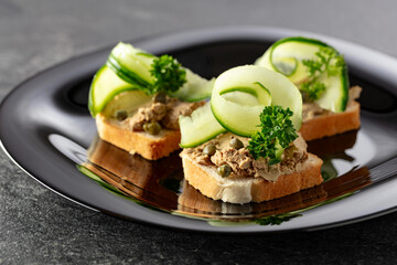 Open sandwiches with pate, fresh cucumber, capers, and parsley.