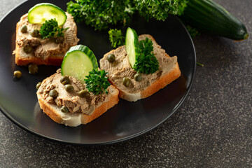 Open sandwiches with pate, fresh cucumber, capers, and parsley.