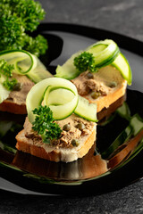 Open sandwiches with pate, fresh cucumber, capers, and parsley.