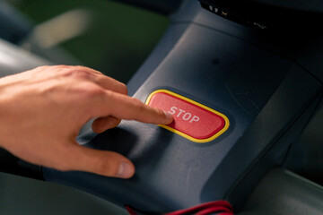 Obraz premium close-up of hand pressing stop button on treadmill after cardio workout technology sport