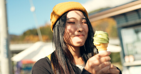 Japanese woman, ice cream and eating in city, summer and walk with thinking, memory or ideas on...