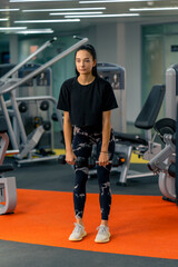Fototapeta na wymiar young girl in sportswear in the gym doing exercises with dumbbells training a healthy lifestyle