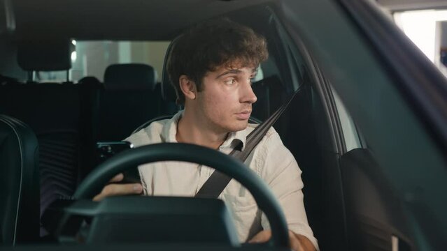 Tired puzzled upset worry anxiety Caucasian man driver male guy sit in car auto businessman frustrated thinking looking at window of automobile holding mobile phone stressed business problem bad news