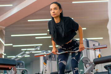 young girl in sportswear in the gym doing barbell exercises fitness training healthy beautiful body