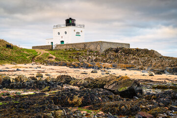 Bamburgh Lighthouse from Harkess Rocks.  Also known as Blackrocks Point Lighthouse and part of...
