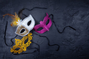 Three vibrant-colored masks together and isolated on a textured black background