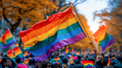 Pride rainbow lgbt gay flag being waved in the Pride Parade. A participant waves a gay rainbow flag at an LGBT gay pride march