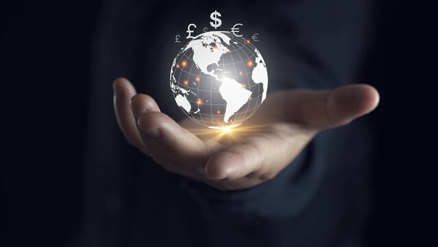 Businessman holding virtual glowing world with currency symbol include dollar yuan yen euro pound sterling won and ruble for global forex exchange and money trade transfers concept
