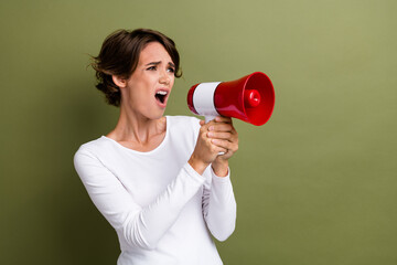 Photo portrait of lovely young lady hold loudspeaker strike activist dressed stylish white garment isolated on khaki color background