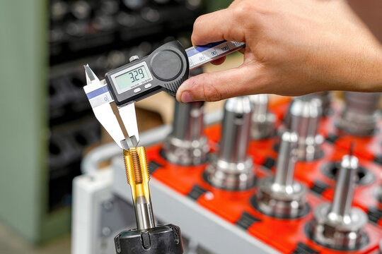 Checking the dimensions of the cutting tool with a caliper for metalworking CNC milling and turning machines.