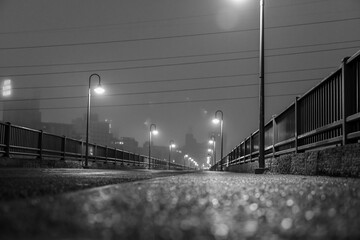 City walking bridge across the river on a foggy morning