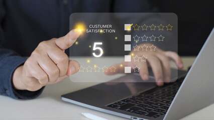 close up Man hand using computer Notebook with popup five star icon for feedback review satisfaction service, Customer service experience and business satisfaction survey.