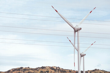 View of wind farm with high wind turbines for generation electricity