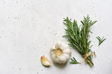 Bunch of rosemary and garlic head - traditional ingredients of mediterranean cuisine. Top view with...