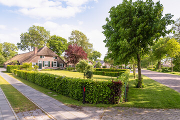 Fototapeta na wymiar Street with characteristic farms in the rural village of Rouveen in the municipality of Staphorst in Overijssel.