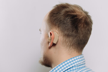 man with a hearing aid on a white background in a shirt without a face