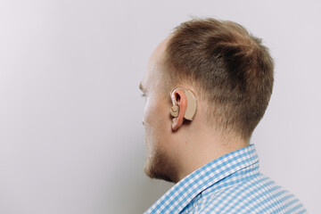 Obraz premium man with a hearing aid on a white background in a shirt without a face