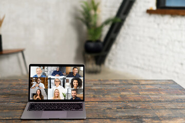 An open laptop on a rustic wooden table displays a virtual meeting with diverse faces on screen, symbolizing the new era of digital collaboration and remote work