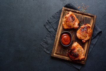 Roasted chicken thighs with ketchup. Top view with copy space. - obrazy, fototapety, plakaty