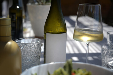 bottiglia di vino sul tavolo imbandito del ristorante - obrazy, fototapety, plakaty