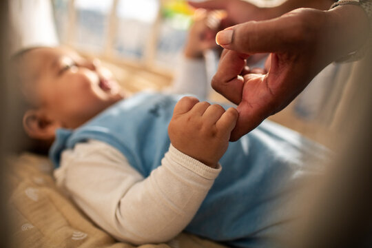 Caring mother spending time with baby son at home