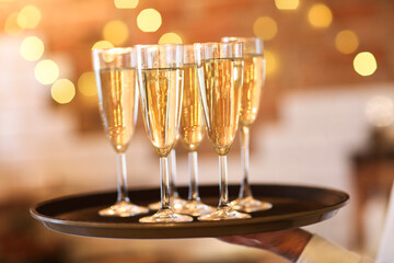 Champagne glasses on tray in bright lights