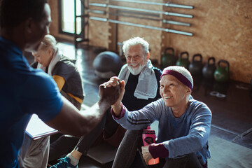 Diverse senior people working out with trainer in gym