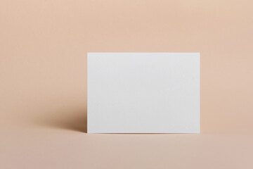 Blank paper greeting or invitation card mockup on beige background, copy space for text or design presentation