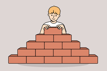 Little boy builds pyramid bricks, wanting to become builder and enroll in architectural university. Child builds sustainable structure, demonstrating architectural and engineering skills