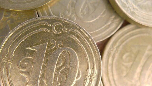 A macro shot of a 10 Kuruş coin with the camera panning from left to right, showing the fine lines and patterns of the currency. The coin is made of copper-plated steel and has a round shape. 