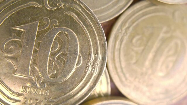 A macro shot of a 10 Kuruş coin with the camera panning from left to right, showing the fine lines and patterns of the currency. The coin is made of copper-plated steel and has a round shape. 