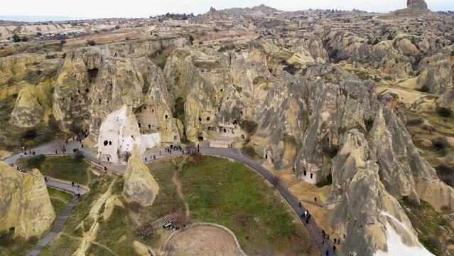 View of the Goreme Open Air Museum in Cappadocia, Turkey. This Unesco World Heritage site is an essential stop on any Cappadocian itinerary. Tourists visiting the historical site.