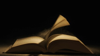 Studio shot of old retro hardcover book on dark background in warm light. Old vintage book laying...
