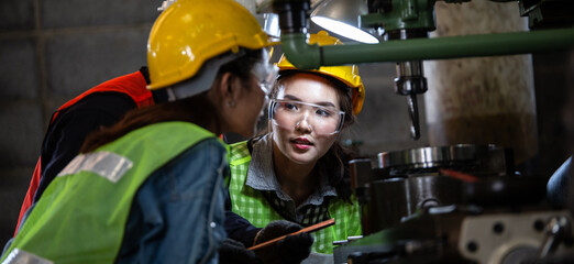 Asian foreman manager showing case study of factory machine to two engineer trainee young woman in protective uniform. teamwork people training and working in industrial manufacturing business © winnievinzence