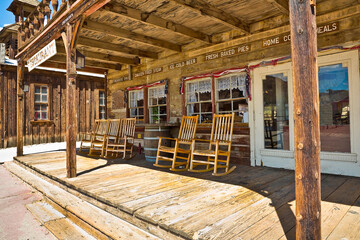 Traditional wooden chairs in a wooden patio Calico - ghost town and former mining town in San Bernardino County - California, United States - Wild west lifestyle - obrazy, fototapety, plakaty