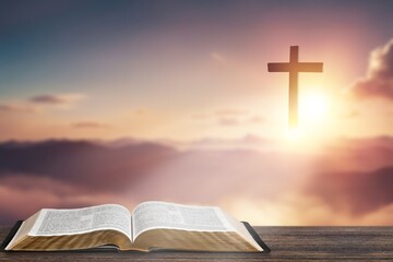 Christian Cross and holly bible book at sunset background