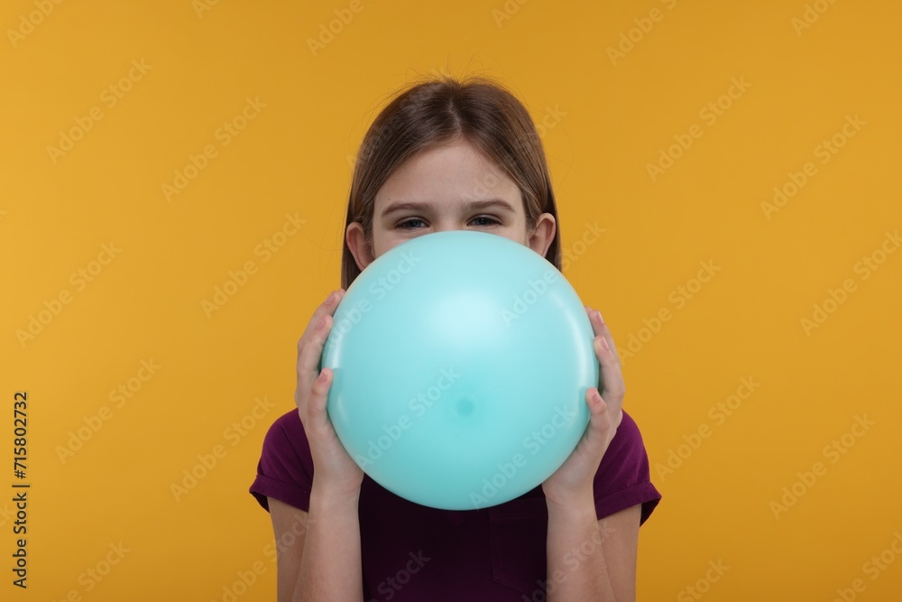 Sticker Girl inflating bright balloon on orange background