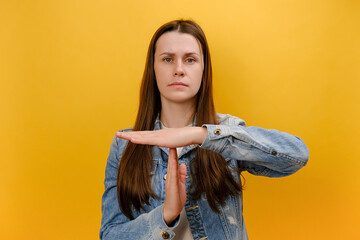 Portrait of displeased young caucasian woman showing time out hand gesture, looking imploringly,...