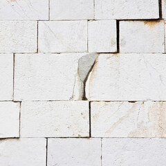 Old deeply cracked and damaged stone wall cause due to subsidence of foundations structural failures