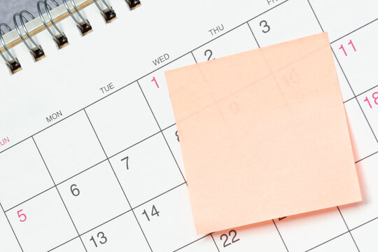 Sticky note on a calendar. Copy space.