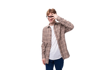 young stylish man with red hair is dressed in a summer plaid shirt