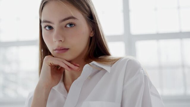 Portrait of young beautiful woman with smooth pure skin. Attractive female model with natural makeup posing on camera. Healthy skin concept.