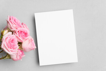 Fototapeta premium Blank invitation card mockup with roses flowers on grey background