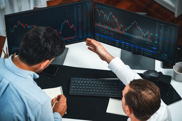 Business professional brokers discussing stock market on pc screen in real time, analyzing dynamic...