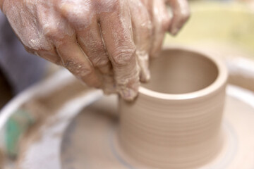 male hands making ceramic cup on pottery wheel, Close-up