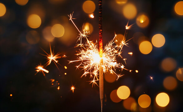 Sparkler burning bright with shiny sparks and bokeh.