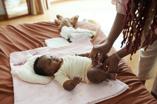 Mother changing diaper of newborn baby girl