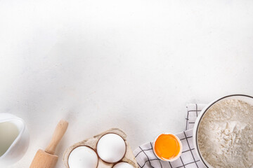 Empty space baking background with bakery ingredients - flour, milk, eggs, rolling pin. Simple...