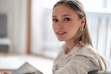 Woman resting at home reading book in modern home interior.