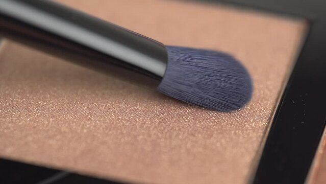 Brush gains shiny brown eyeshadow or blush. Cosmetic swatch.